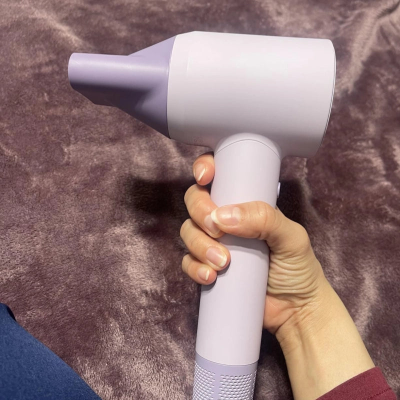 Hand holding a  hair dryer on a brown textured surface