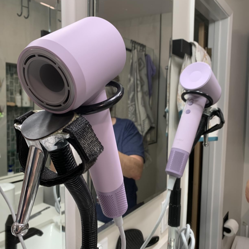 Purple hair dryer attached to a stand in a bathroom setting