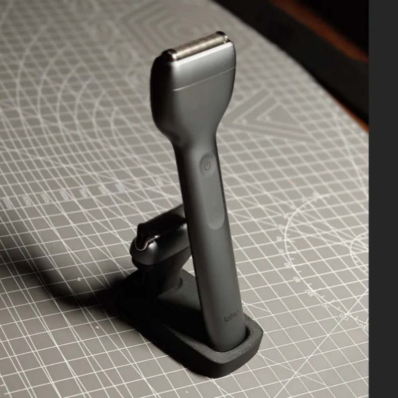 Black electric shaver on a grid-patterned surface
